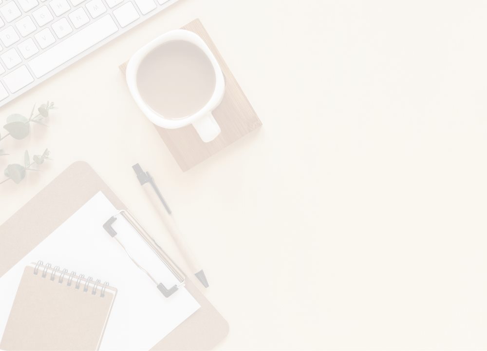 Notebook, coffee cup, pen, and keyboard arranged on a desk for a working session
